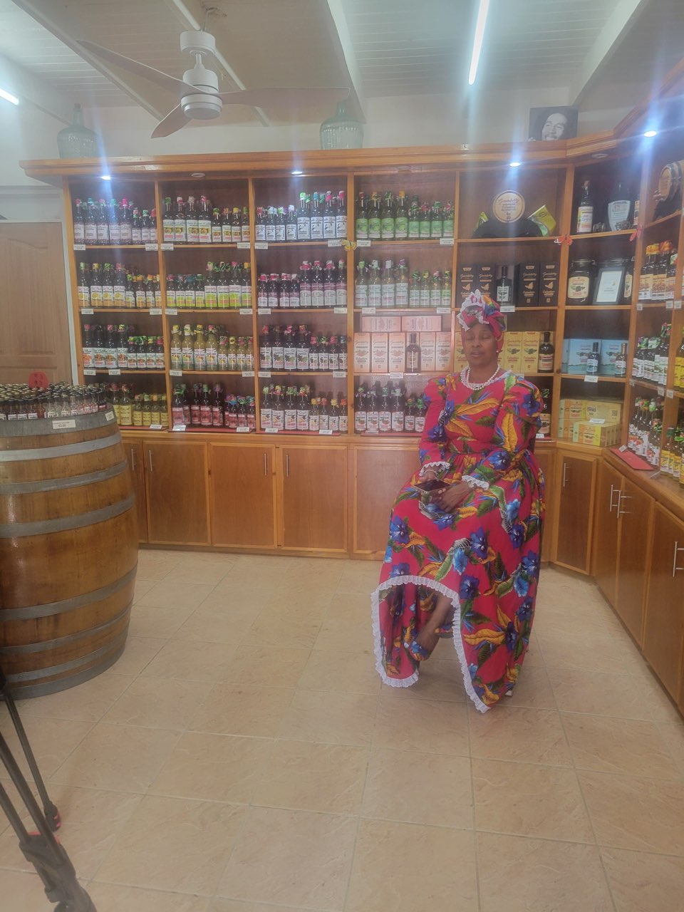 A tradition bearer in traditional dress seated in the guavaberry shop